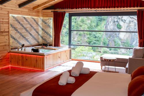 a living room with a tub and a large window at Gale Suit in Çamlıhemşin