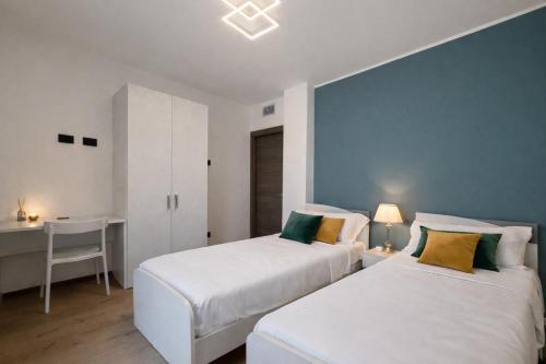 two beds in a room with a desk and a table at Villa Lake Luxury in Colico
