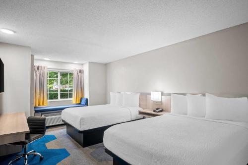 a hotel room with two beds and a desk at Microtel Inn Georgetown - Lexington North in Georgetown