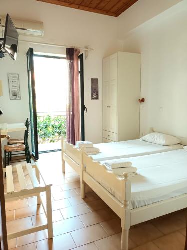 a bedroom with two beds and a large window at Skardamoula's Studios n Apartments in Kardamyli