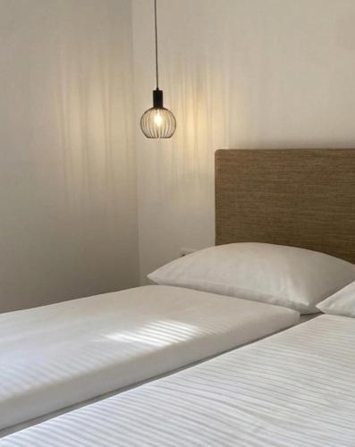 a bedroom with two beds and a light at Fischerhof in Cortaccia