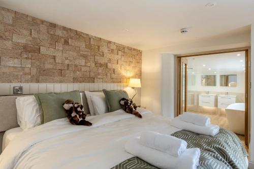 a large white bed with two teddy bears on it at 5 Bed in Bishops Lydeard oc-b45427 in  Liscombe