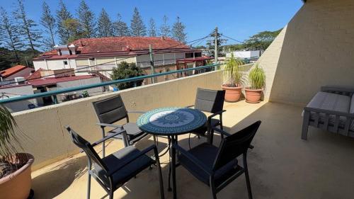 a patio with a table and chairs on a balcony at Ahoy Brunswick 1 in Brunswick Heads