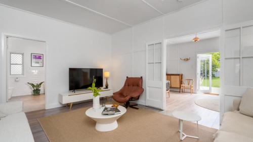 a living room with a couch and a tv at Bruns Beach Shack in Brunswick Heads