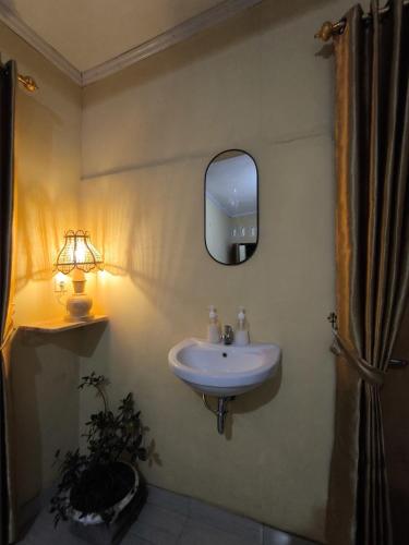 a bathroom with a sink and a mirror on the wall at Tetebatu Clove Garden in Tetebatu