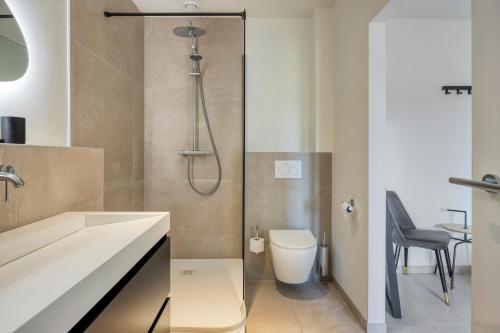 a bathroom with a shower with a toilet and a sink at Hoeve de Eik in Epen
