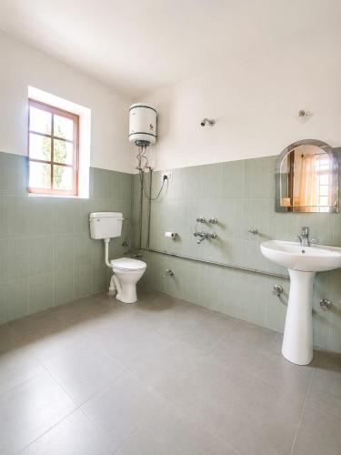 a bathroom with a sink and a toilet and a window at Zotpa Hostel in Leh