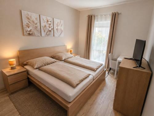 a bedroom with a bed with a television and a desk at MarchfeldStay in Gänserndorf