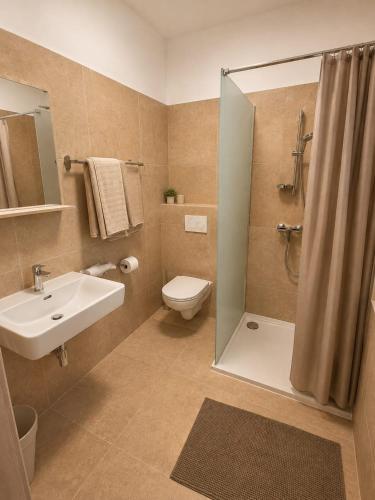 a bathroom with a sink and a toilet and a shower at MarchfeldStay in Gänserndorf