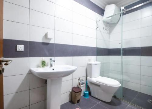 a bathroom with a toilet and a sink at Tcc - Skysuites in Accra