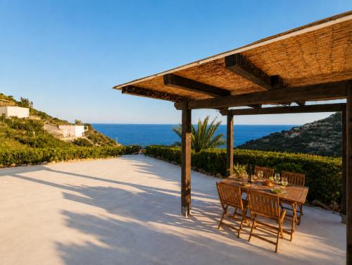 a table and chairs under a pavilion next to the ocean at Maridea - Vairone in Ponza