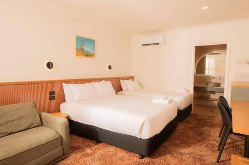 a hotel room with a bed and a couch at The Alluna Motel, an Ascend Collection Hotel in Armidale