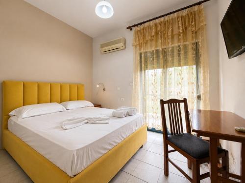 a bedroom with a bed and a desk and a window at Hotel Palma in Gjirokastër