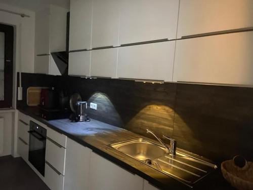 a kitchen with a sink and white cabinets at Ferienwohnung Fein in Bad Sachsa
