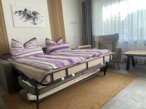 a bed with purple pillows on it in a room at Ferienwohnung Fein in Bad Sachsa