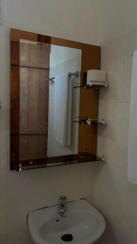 a bathroom with a sink and a mirror at Shalom Homestay in Kilindoni