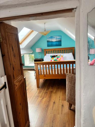 a bedroom with a bed and a blue wall at Donegal Cottage in Inver