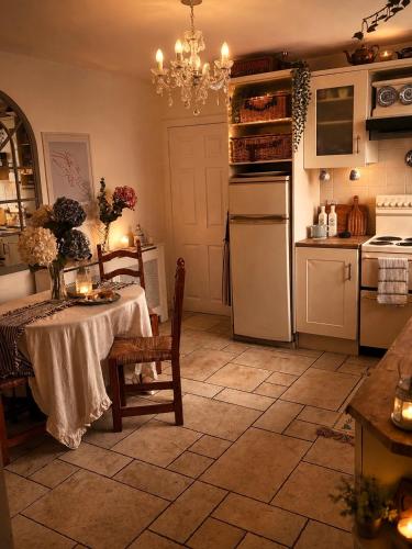 a kitchen with a table and a kitchen with a chandelier at Donegal Cottage in Inver