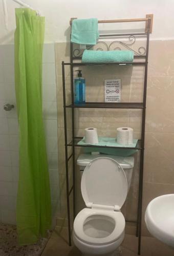 a bathroom with a toilet and towels and a sink at Yayi Maria in Río Hato