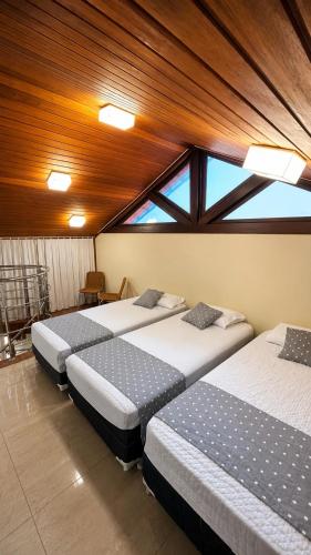 three beds in a room with a large window at Flat Monte Castelo ,Vista Incrível,Conforto in Sairé