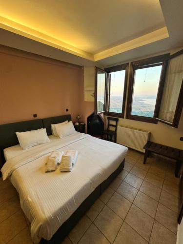 a bedroom with a bed with two towels on it at RASTONI Pelion in Vyzitsa