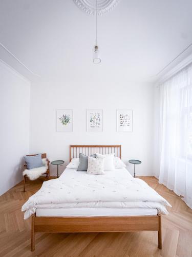 a white bedroom with a bed and two tables at Apartmány Tyršovka - u Janských Lázní, Krkonoše in Svoboda nad Úpou