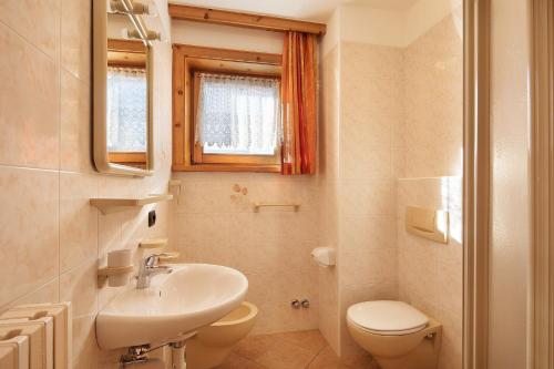 a bathroom with a sink and a toilet and a mirror at Baita sulle Alpi Livigno in Livigno