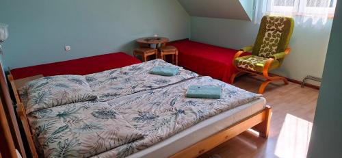 a small bedroom with a bed and a chair at U Janusza in Zadwórze