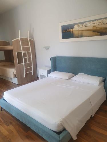 a bedroom with a large bed with a blue headboard at Masseria SoleMare Gallipoli in Pizzo