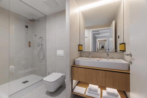 a bathroom with a sink and a toilet and a mirror at Hotel Garden Istra Plava Laguna in Umag