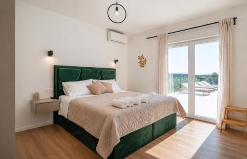 a bedroom with a large bed with two towels on it at Villa Tea Polača Biograd na moru Benkovac in Polača