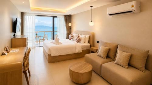 ein Hotelzimmer mit einem Bett und einer Couch in der Unterkunft ROZ MARINE Boutique Hotel in Bophut 