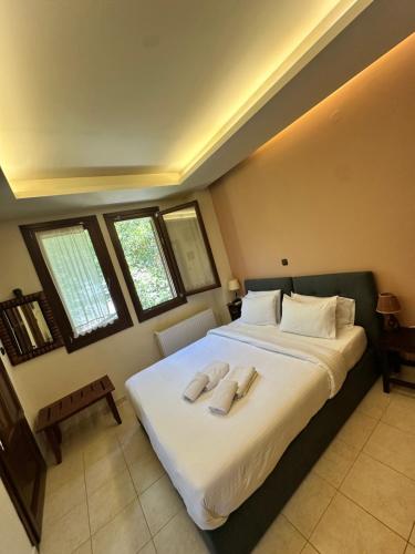 a bedroom with a large bed with towels on it at RASTONI Pelion in Vyzitsa
