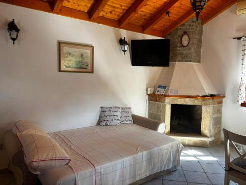 a living room with a bed and a fireplace at House Zrno Peaceful Stone House in Račišće, Korčula in Račišće