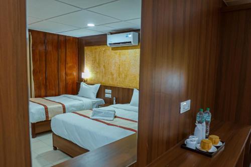 a hotel room with two beds and a mirror at Batika Resort Sauraha in Sauraha