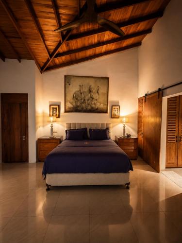 a bedroom with a large bed in a room with wooden ceilings at Villa Blue Lotus Katunayake- Colombo Airport in Katunayaka