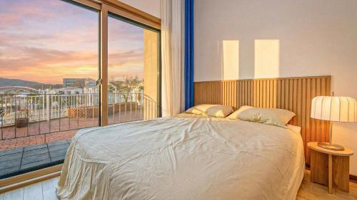 a bedroom with a large bed and a large window at Chuncheon Lio Pension in Chuncheon