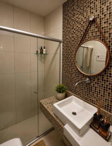 a bathroom with a sink and a shower and a mirror at Flat Monte Castelo ,Vista Incrível,Conforto in Sairé