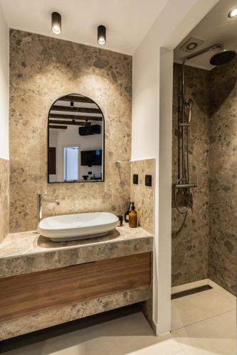 a bathroom with a tub and a mirror at Aiolos Suites in Rhodes Town