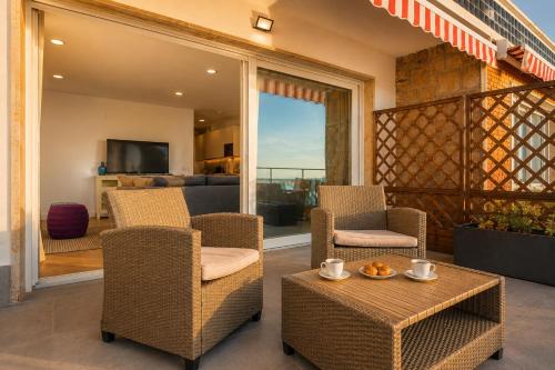 a patio with chairs and a table and a living room at Panther Home Manantial in El Puerto de Santa María