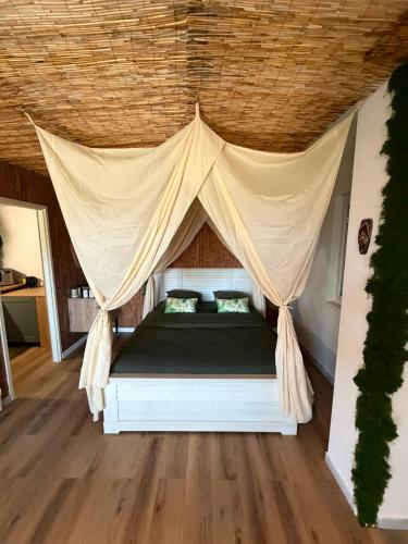 a bedroom with a bed with a mosquito net at L'EVIDENCE Love Room & spa in Chaveignes