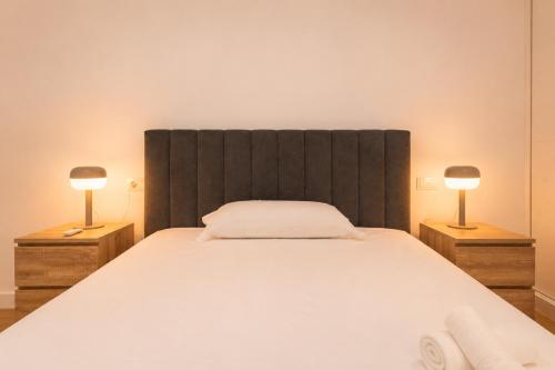 a bedroom with a large bed with two lamps on night stands at Panther Home Manantial in El Puerto de Santa María