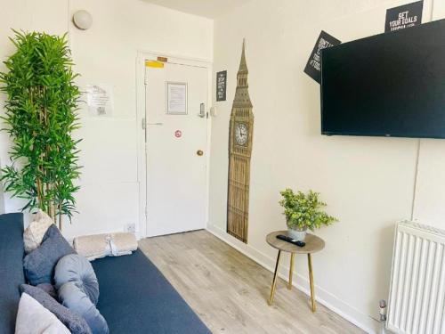 a living room with a couch and a clock on the wall at Big Group Stays in Brighton & Hove