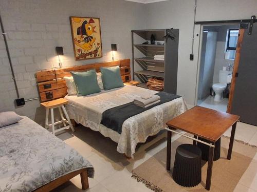 a bedroom with a bed and a desk and a table at The Regiment Self Catering Accommodation has 3 x 4 sleeper units in Cape Town