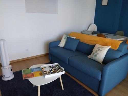a living room with a blue couch and a table at Gosen appart in Athis-Mons