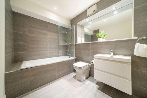 a bathroom with a toilet and a tub and a sink at Whinny Brae in Broughty Ferry