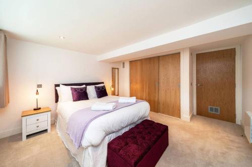 a bedroom with a large white bed and a red stool at Whinny Brae in Broughty Ferry