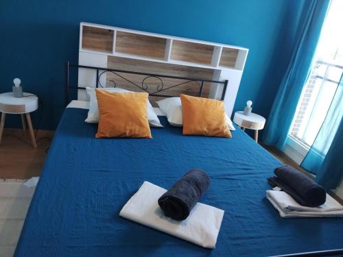 a blue bedroom with a bed with towels on it at Gosen appart in Athis-Mons