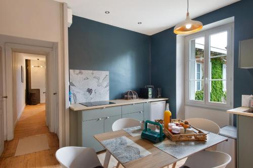 a kitchen with blue walls and a table and chairs at B&B L'Annexe De Camillac in Bourg-sur-Gironde