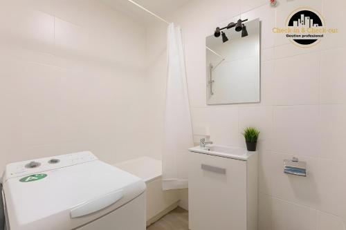 a white bathroom with a sink and a mirror at El Bajondillo Apartment in Torremolinos